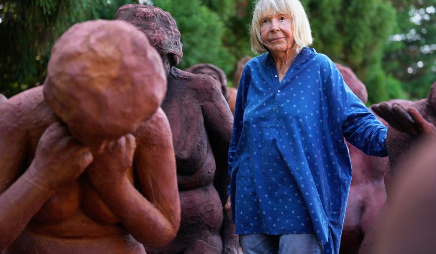 Artist Suse Lowenstein, whose son, Alex, was killed in the bombing of Pan Am Flight 103 over Lockerbie, Scotland, poses for a photograph amongst the figures thats make up her sculpture titled "Dark Elegy" in her backyard in Montauk, N.Y., Wednesday, Aug. 19, 2026. (AP Photo/Seth Wenig)