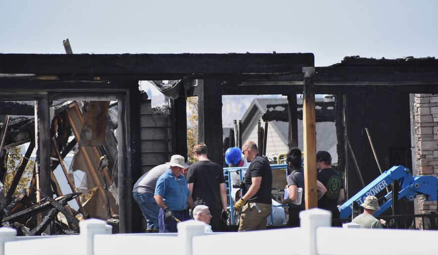 Investigators work at the scene Tuesday, Aug. 25, 2026, where a family was killed and the house burned in Billings, Mont. (AP Photo/Matthew Brown)
