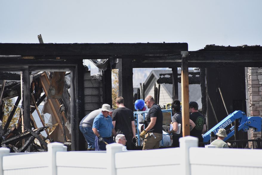 Investigators work at the scene Tuesday, Aug. 25, 2026, where a family was killed and the house burned in Billings, Mont. (AP Photo/Matthew Brown)