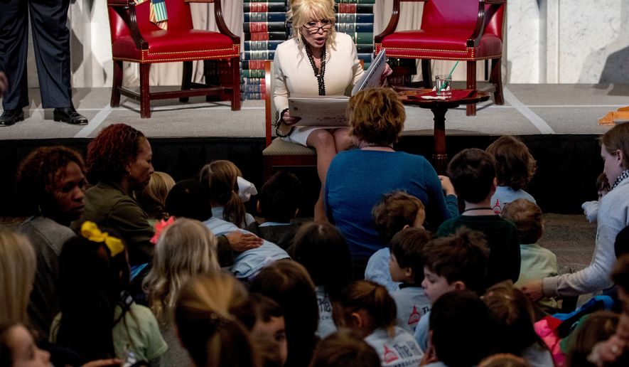 FILE - Dolly Parton reads her book "Coat of Many Colors," at the Library of Congress in Washington on Feb. 27, 2018. (AP Photo/Andrew Harnik, File)
