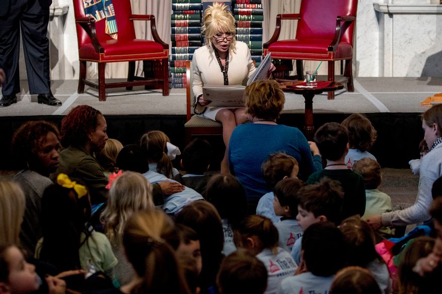FILE - Dolly Parton reads her book "Coat of Many Colors," at the Library of Congress in Washington on Feb. 27, 2018. (AP Photo/Andrew Harnik, File)