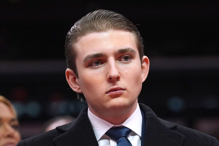 FILE - Barron Trump watches as his father, President Donald Trump attends an indoor Presidential Inauguration parade event at Capital One Arena, in Washington, Jan. 20, 2025. (AP Photo/Evan Vucci, File)