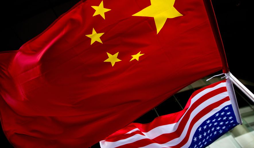 In this Nov. 7, 2012 photo, U.S. and Chinese national flags are hung outside a hotel during the U.S. presidential election event, organized by the U.S. embassy in Beijing. (AP Photo/Andy Wong) **FILE**