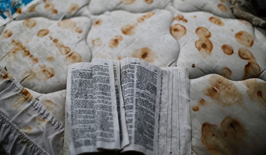 A bible sits on a stained mattress on a pile of debris outside a damaged motel from Hurricane Michael in Panama City, Fla, Jan. 23, 2019. (AP Photo/David Goldman, File)
