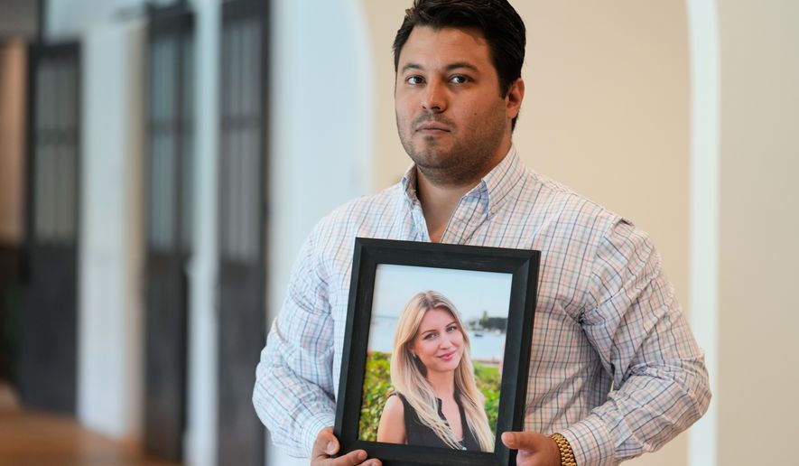Harold Jezler poses for a picture with a photo of his wife, Olga Jezler, in West Harrison, N.Y., Friday, Aug. 21, 2026. (AP Photo/Seth Wenig)