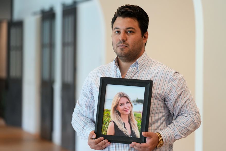 Harold Jezler poses for a picture with a photo of his wife, Olga Jezler, in West Harrison, N.Y., Friday, Aug. 21, 2026. (AP Photo/Seth Wenig)
