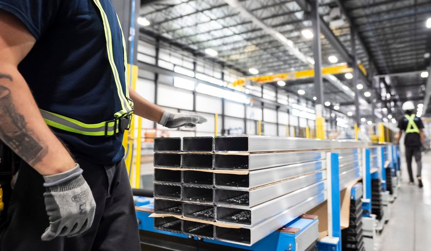 FILE - Workers prepare extruded aluminum product for packaging at Magna Aluminum Profile's fully electric powered extrusion facility in Salaberry-de-Valleyfield, Quebec, Canada, on Sept. 3, 2025. (Christopher Katsarov/The Canadian Press via AP, File)