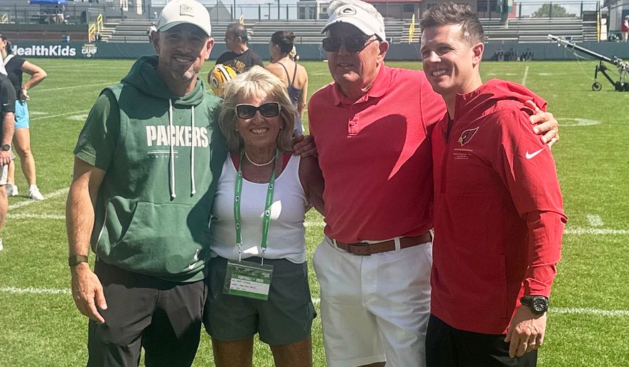 Green Bay Packers coach Matt LaFleur, left, and his younger brother, Arizona Cardinals coach Mike LaFleur, pose for a photo with their parents, Kristi and Denny LaFleur, center, after the Packers’ and Cardinals’ joint practice, Wednesday, Aug. 26, 2026, in Green Bay, Wis. (AP Photo/Steve Megargee)