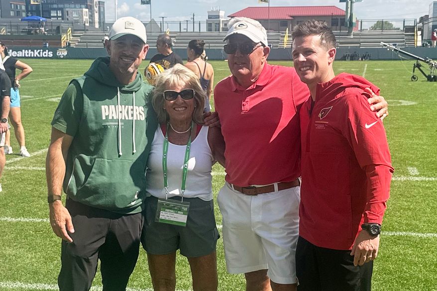 Green Bay Packers coach Matt LaFleur, left, and his younger brother, Arizona Cardinals coach Mike LaFleur, pose for a photo with their parents, Kristi and Denny LaFleur, center, after the Packers’ and Cardinals’ joint practice, Wednesday, Aug. 26, 2026, in Green Bay, Wis. (AP Photo/Steve Megargee)