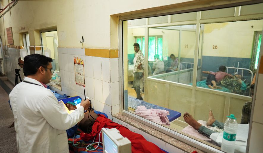 FILE - Dr. Abhishek Pranayami examines a patient suffering from a heat-related illness amid high temperatures at a district government hospital in Banda, northern Indian state of Uttar Pradesh, June 19, 2026 (AP Photo/Rajesh Kumar Singh, File)
