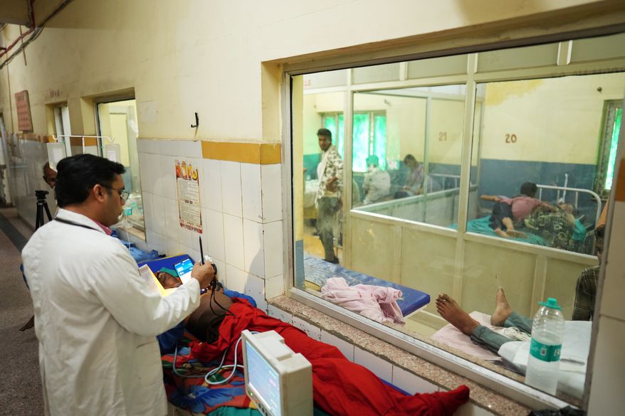 FILE - Dr. Abhishek Pranayami examines a patient suffering from a heat-related illness amid high temperatures at a district government hospital in Banda, northern Indian state of Uttar Pradesh, June 19, 2026 (AP Photo/Rajesh Kumar Singh, File)