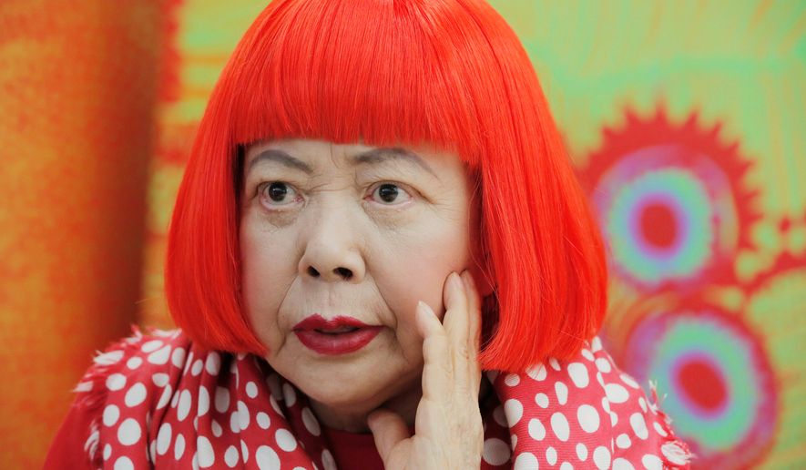 Japanese avant-garde artist Yayoi Kusama, wearing a bright red wig and a Louis Vuitton scarf with polka dots, speaks during an interview at her studio in Tokyo, on Aug. 1, 2012. (AP Photo/Itsuo Inouye, File)