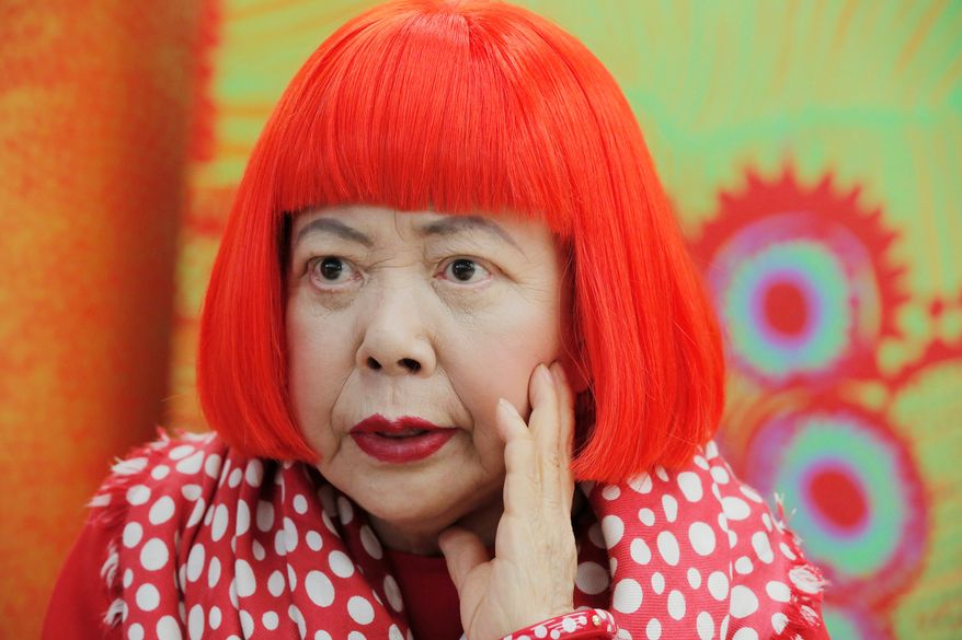 Japanese avant-garde artist Yayoi Kusama, wearing a bright red wig and a Louis Vuitton scarf with polka dots, speaks during an interview at her studio in Tokyo, on Aug. 1, 2012. (AP Photo/Itsuo Inouye, File)