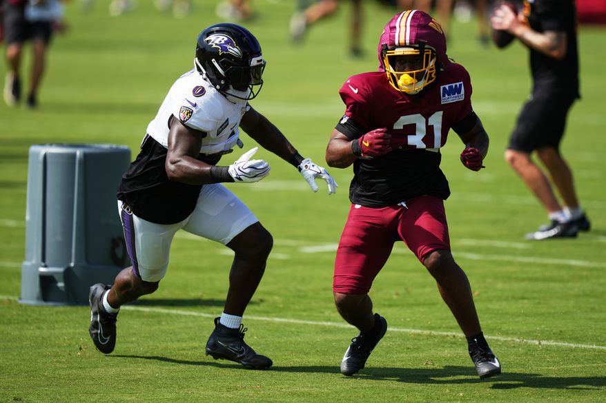 Baltimore Ravens linebacker Roquan Smith (0) and Washington Commanders cornerback Rasul Douglas (31) work out during the teams' NFL football joint training camp, Wednesday, Aug. 26, 2026, at the Under Armour Performance Center in Owings Mills, Md. (AP Photo/Stephanie Scarbrough)