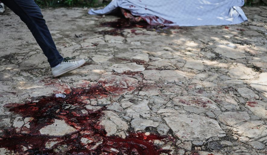 Blood stains the ground left behind by the victim of a gang attack in the Kenscoff neighborhood of Port-au-Prince, Haiti, Monday, Aug. 24, 2026. (AP Photo/Odelyn Joseph)