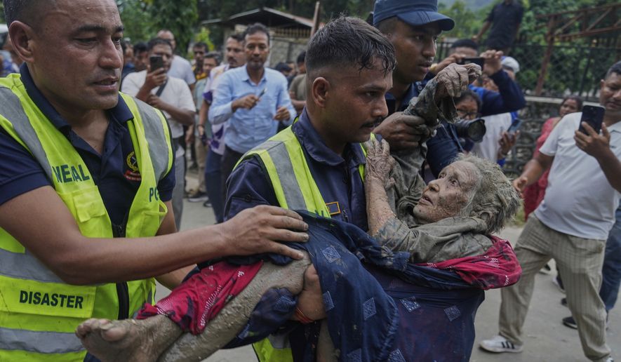 Rescuers carry a victim of flash flooding to safety along the Trishuli River in Nepal's Nuwakot district, Wednesday, Aug. 26, 2026. (AP Photo/Niranjan Shrestha)
