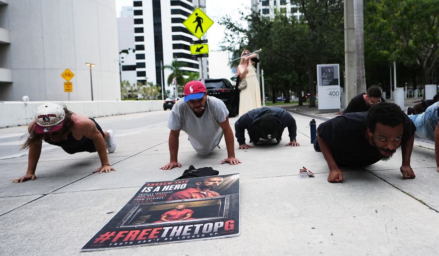 Supporters of Andrew and Tristan Tate do push-ups outside of the C. Clyde Atkins U.S. Courthouse as the Tate brothers fight extradition to the United Kingdom on charges of rape and sex trafficking in Miami, Thursday, Aug. 27, 2026. (AP Photo/Lynne Sladky)