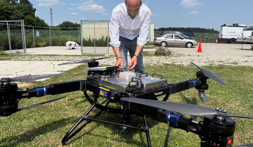 Volatus Aerospace COO Greg Colacitti inspects a heavy lift drone before a test run on July 13, 2026, in Kleinburg, Ontario. (AP Photo/Kelvin Chan)