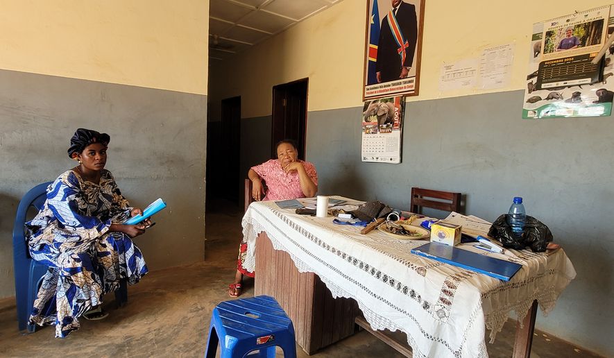 Parents who came for their children's school resumption sit inside an office of a school in Ituri province, eastern Congo, Thursday, Aug. 27, 2026. (AP Photo/Constant Same Bagalwa)