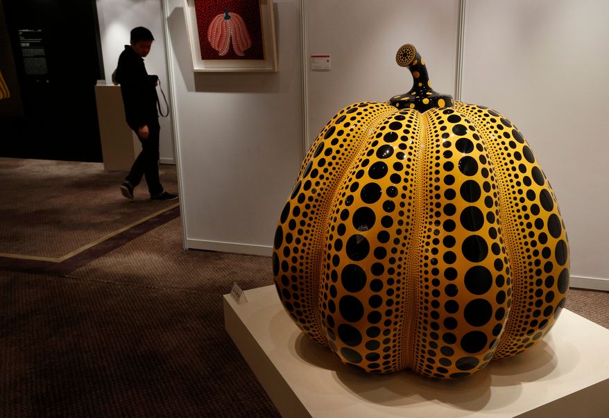FILE - A man walks past a work " Pumpkin " by Japanese artist Yayoi Kusama during the Ravenel auction press preview in Hong Kong Friday, Nov. 23, 2012. (AP Photo/Vincent Yu, File)