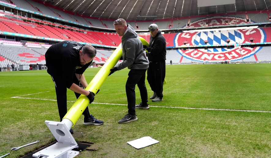 FILE - Workers prepare a goal post inside the FC Bayern Munich soccer stadium for an NFL football game at Allianz Arena in Munich, Germany, Wednesday, Nov. 9, 2022. (AP Photo/Matthias Schrader, File(