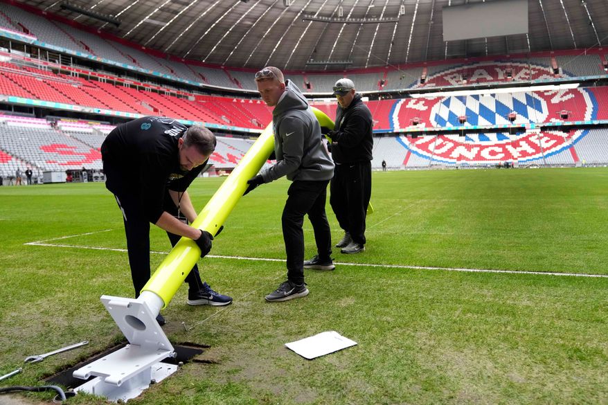FILE - Workers prepare a goal post inside the FC Bayern Munich soccer stadium for an NFL football game at Allianz Arena in Munich, Germany, Wednesday, Nov. 9, 2022. (AP Photo/Matthias Schrader, File(
