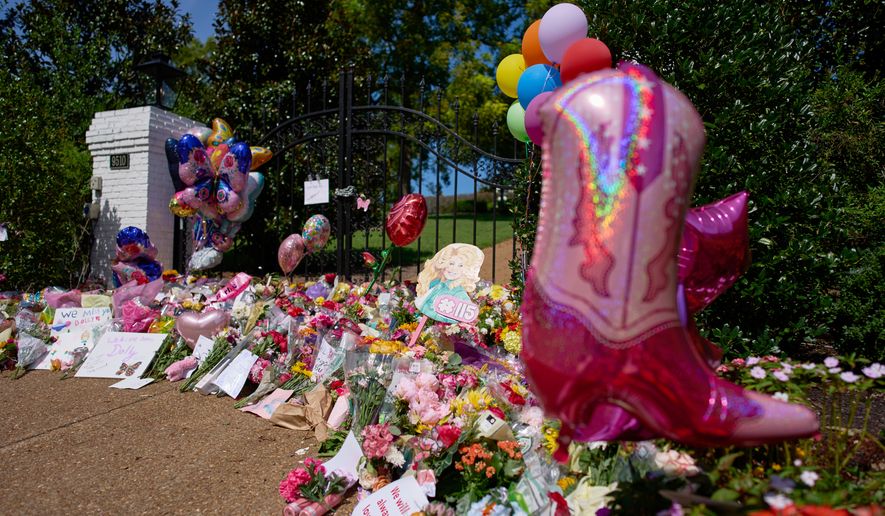 Flowers, cards and balloons are seen at a memorial outside the home of the late Dolly Parton, Thursday, Aug. 27, 2026, in Brentwood, Tenn. (AP Photo/George Walker IV)