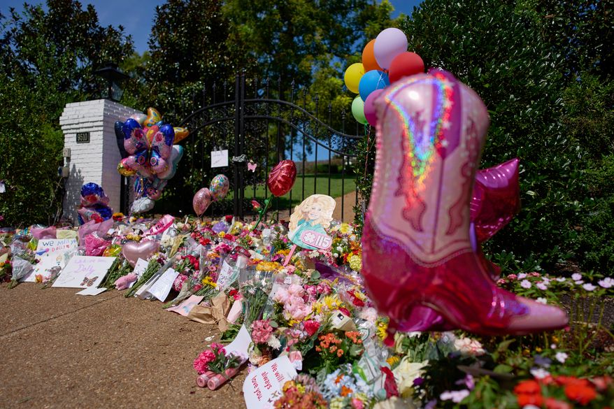 Flowers, cards and balloons are seen at a memorial outside the home of the late Dolly Parton, Thursday, Aug. 27, 2026, in Brentwood, Tenn. (AP Photo/George Walker IV)