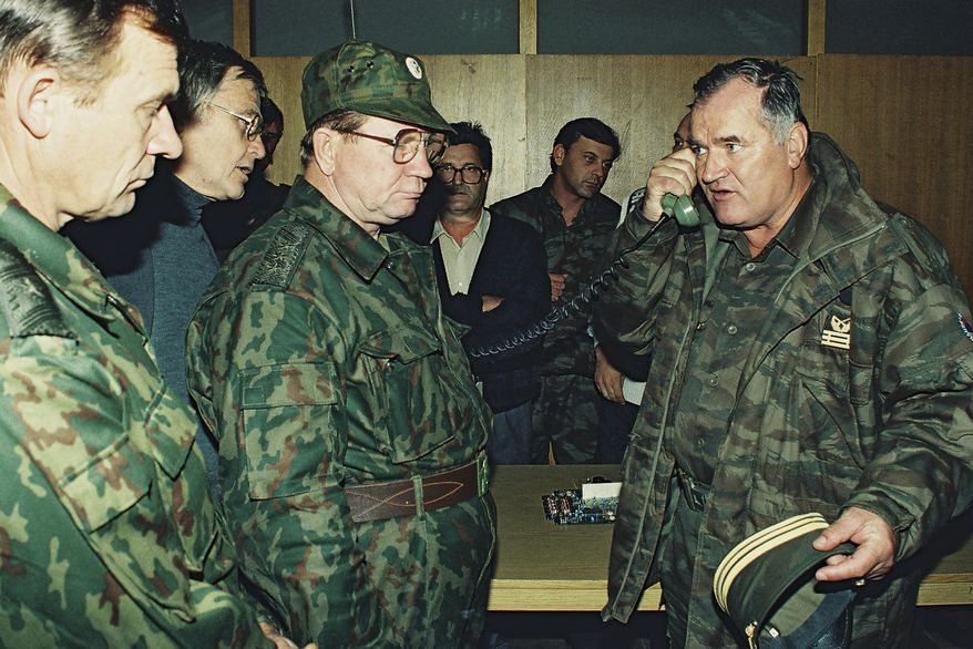 Bosnian Serb Gen. Ratko Mladic, right, talks on the phone next to Russian Army Gen. Vladimir Zurbenko, center, during the visit of a Russian Army delegation to the Bosnian town of Banja Luka in Oct. 1995. (AP Photo/Radivoje Pavicic, File)