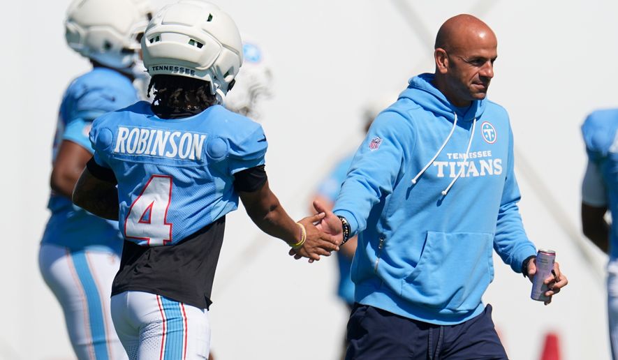 Tennessee Titans head coach Robert Saleh, right, greets wide receiver Wan'dale Robinson (4) during the NFL football team's training camp Tuesday, Aug. 25, 2026, in Nashville, Tenn. (AP Photo/George Walker IV)