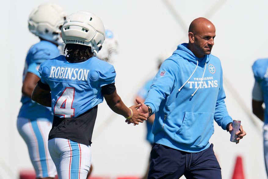 Tennessee Titans head coach Robert Saleh, right, greets wide receiver Wan'dale Robinson (4) during the NFL football team's training camp Tuesday, Aug. 25, 2026, in Nashville, Tenn. (AP Photo/George Walker IV)