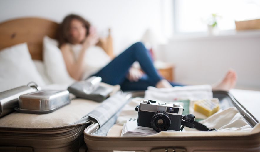 A solo traveler prepares for a trip abroad. (Photo by Halfpoint on Shutterstock)