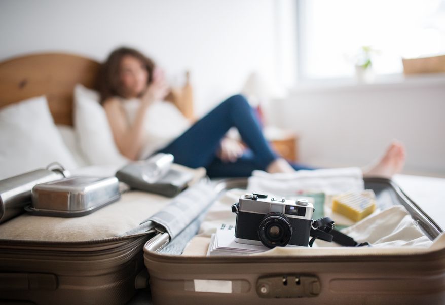 A solo traveler prepares for a trip abroad. (Photo by Halfpoint on Shutterstock)