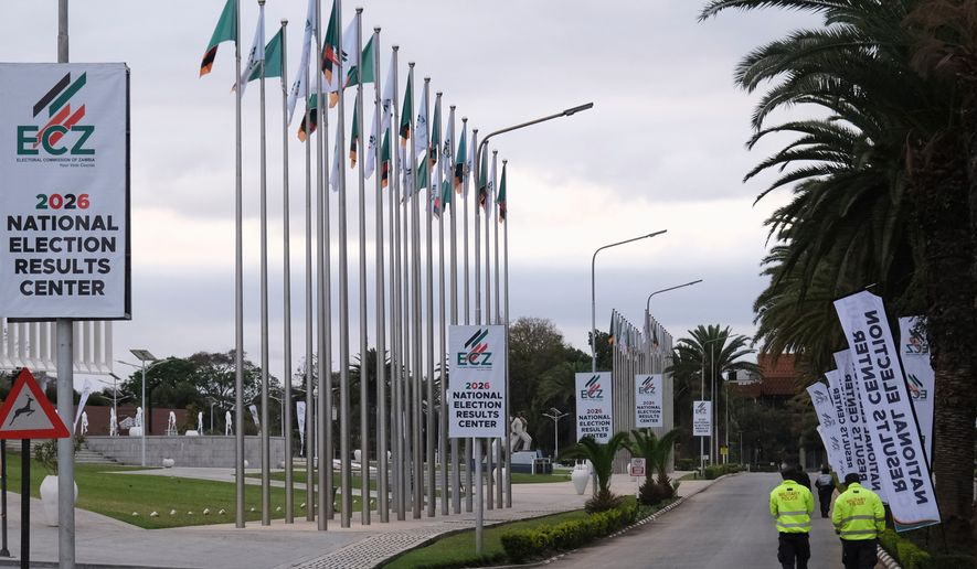Zambian army officers walk outside the precinct of the election results center at the Mulungushi International Conference Centre in Lusaka, Zambia, Friday, Aug. 14, 2026. (AP Photo/Anita Reed)
