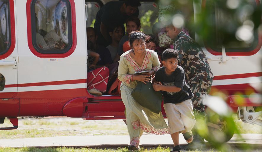 Army soldiers help a family disembark from a helicopter after they are rescued from an area affected by flash flooding in Nepal's Nuwakot district, Friday, Aug. 28, 2026. (AP Photo/Rajesh Kumar Singh)