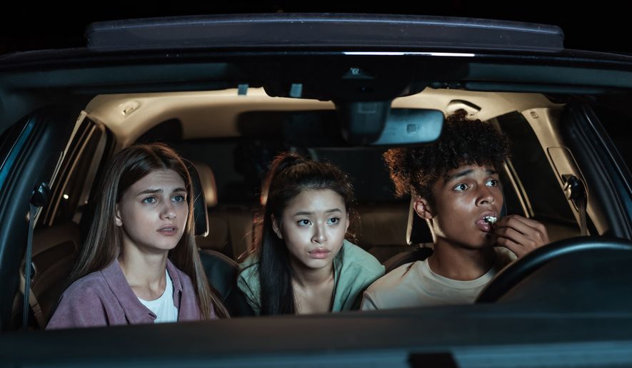 FILE: Young friends watch a thriller from their car at a drive-in movie theater. (Credit: BAZA Production)