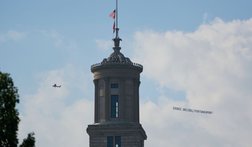 A plane flies over Nashville, Tenn., towing a banner reading “change.org/DollyPartonAirport” as part of an effort to rename the airport after Dolly Parton, Friday, Aug. 28, 2026. (AP Photo/George Walker IV)