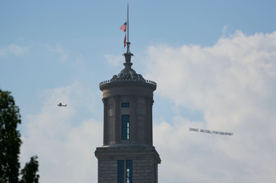 A plane flies over Nashville, Tenn., towing a banner reading “change.org/DollyPartonAirport” as part of an effort to rename the airport after Dolly Parton, Friday, Aug. 28, 2026. (AP Photo/George Walker IV)