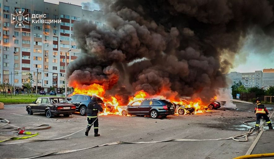 In this photo provided by the Ukrainian Emergency Service, cars burn as firefighters try to put out a fire following a Russian drone attack in Kyiv region, Ukraine, Friday, Aug. 28, 2026. (Ukrainian Emergency Service via AP)