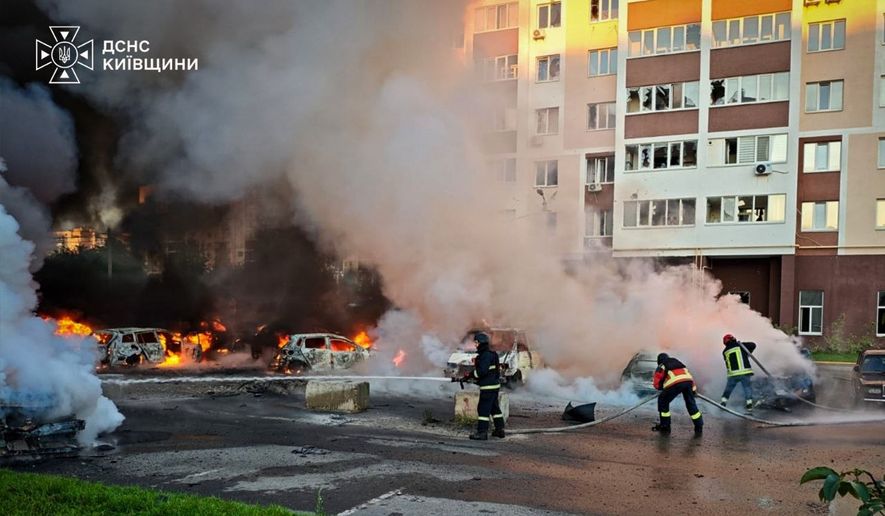 In this photo provided by the Ukrainian Emergency Service, cars burn as firefighters try to put out a fire following a Russian drone attack in Kyiv region, Ukraine, Friday, Aug. 28, 2026. (Ukrainian Emergency Service via AP)