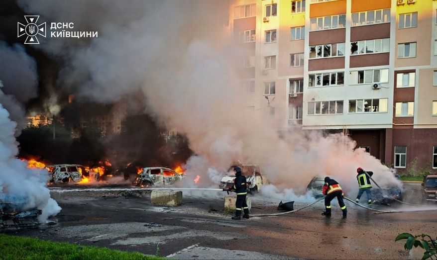 In this photo provided by the Ukrainian Emergency Service, cars burn as firefighters try to put out a fire following a Russian drone attack in Kyiv region, Ukraine, Friday, Aug. 28, 2026. (Ukrainian Emergency Service via AP)
