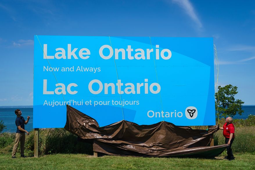 Ontario Premier Doug Ford, right, and Niagara West Member of Provincial Parliament Sam Oosterhoff unveil a sign for Lake Ontario at the Fifty Point Conservation Area in Grimsby, Ontario, Canada, on Saturday, Aug. 29, 2026. (Keito Newman/The Canadian Press via AP)