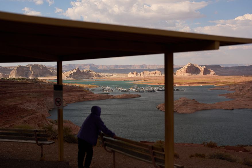 A person stands at an overlook near the Wahweap Marina on Lake Powell at the Glen Canyon National Recreation Area, July 15, 2026, near Page, Ariz. (AP Photo/John Locher, File)