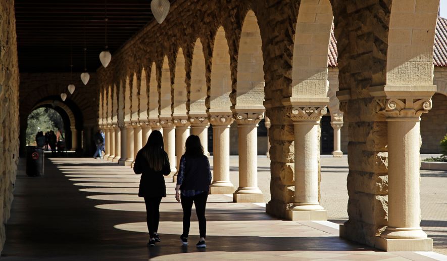 Students walk through the Stanford University campus, March 14, 2019, in Santa Clara, Calif. (AP Photo/Ben Margot, File)