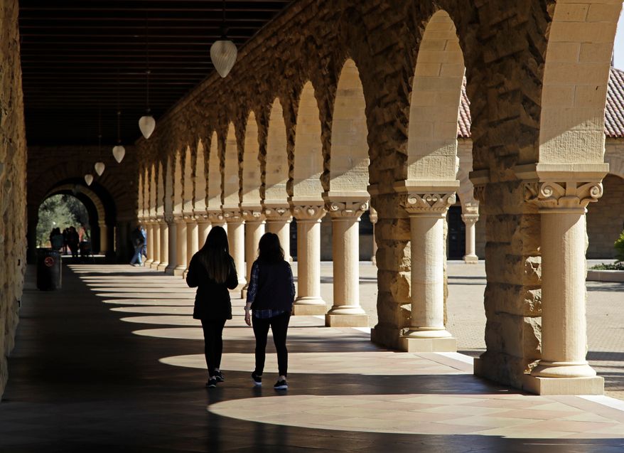 Students walk through the Stanford University campus, March 14, 2019, in Santa Clara, Calif. (AP Photo/Ben Margot, File)