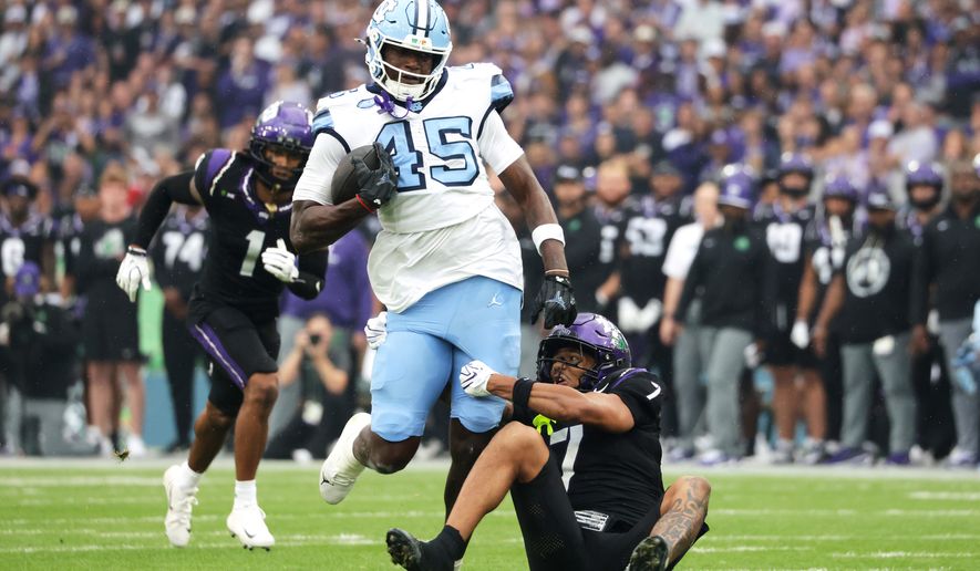 TCU safety Julius Simms, right, tackles North Carolina tight end Jelani Thurman during an NCAA college football game in Dublin, Ireland. Saturday, Aug. 29, 2026. (AP Photo/Peter Morrison)