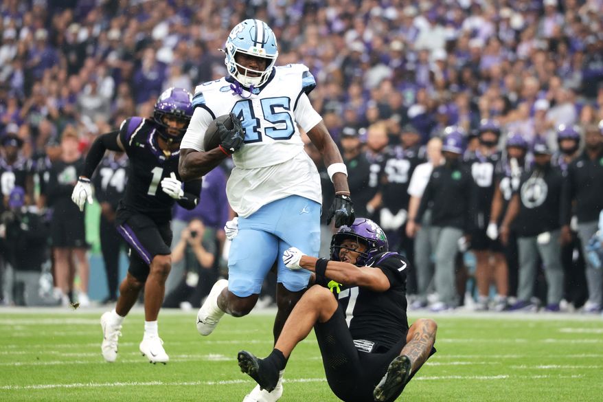 TCU safety Julius Simms, right, tackles North Carolina tight end Jelani Thurman during an NCAA college football game in Dublin, Ireland. Saturday, Aug. 29, 2026. (AP Photo/Peter Morrison)