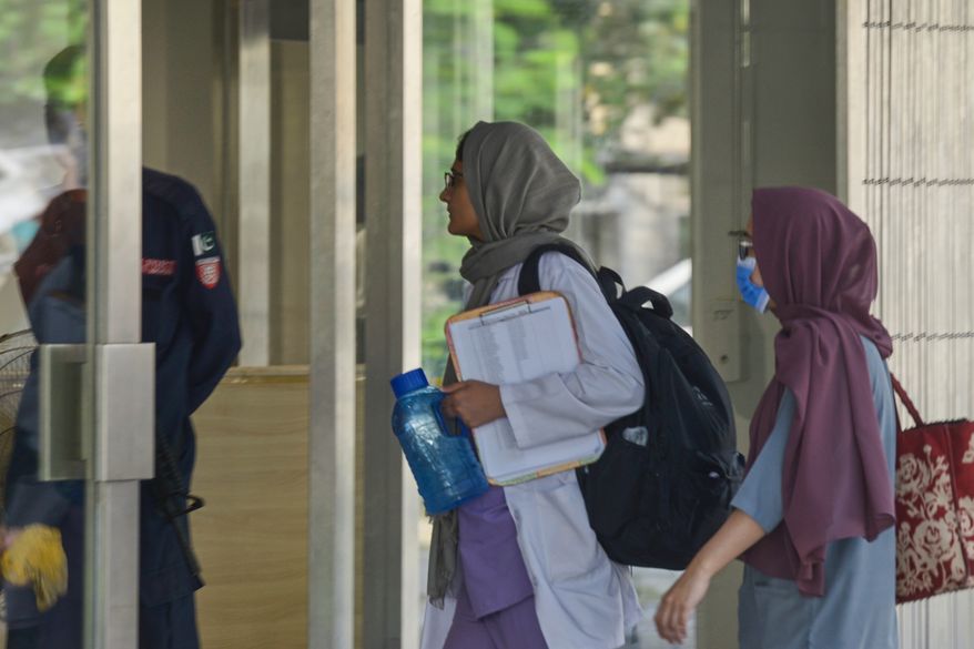 Hospital staff enter the Mother and Child Health ward at the Pakistan Institute of Medical Sciences, in Islamabad, Pakistan, Thursday, Aug. 27, 2026. (AP Photo/M.A. Sheik)