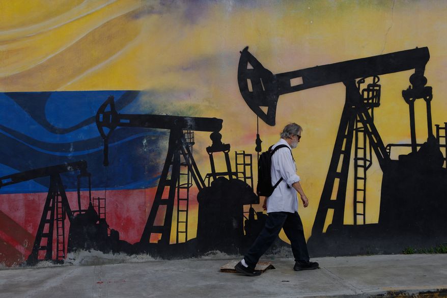 A pedestrian walks past a mural featuring oil wells in Caracas, Venezuela, Saturday, Aug 29, 2026, a day after President Donald Trump announced a deal giving the United States a stake in Venezuela’s oil reserves. (AP Photo/Pedro Mattey)