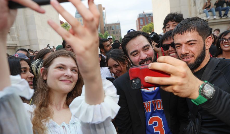 Amadeo Fusca, center, winner of the Mayor Zohran Mamdani look-alike contest, takes selfies with the crowd, Sunday, Aug. 30, 2026, in New York. (AP Photo/Heather Khalifa)